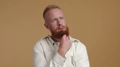 Close-up view of a young man in his 30s, looking above while overthinking Stock Footage 223973488