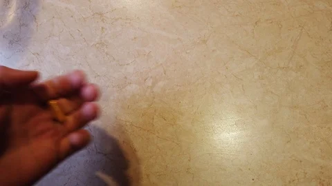 Close up view of young man holding ginseng vitamins and minerals pills in hand a 動画素材 103173521