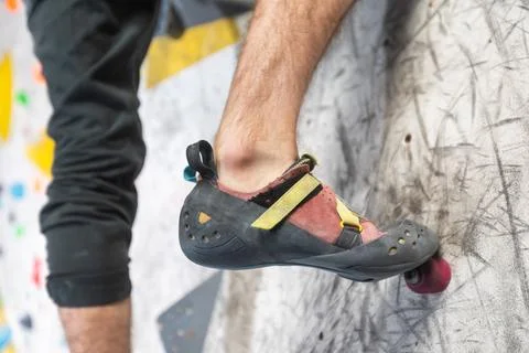 Close up view of young man or climber feet in climbing shoes on artificial 库存照片