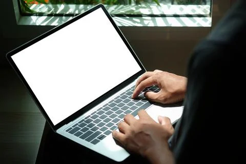 Close up view young man sitting in living room and using computer laptop. Stock Photos