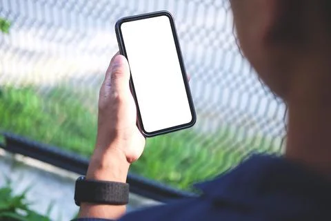 Close up view young man using smart phone while sitting in the backyard. Foto stock