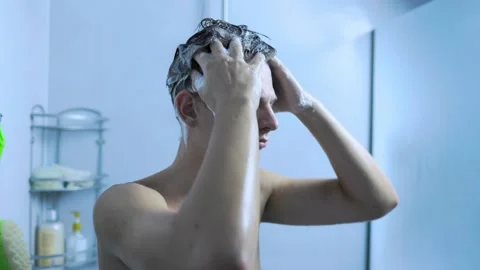 Close up view of a young man washing his hair under the shower at home. Stock Footage 345531050