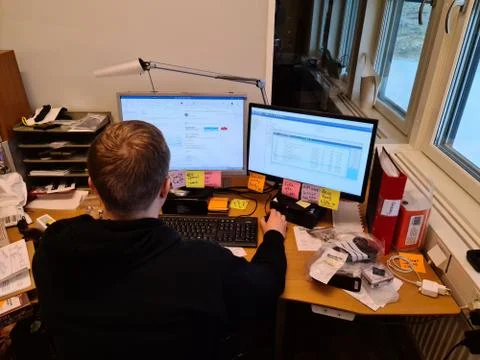 Close up view of young man at work. Computer screens with post it notes. Stock Photos