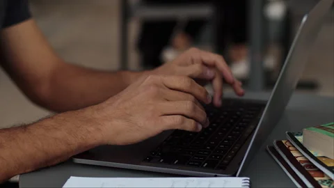 Close-up view of a young man working on a laptop, pushing buttons outdoors, nice Stock Footage 253971844
