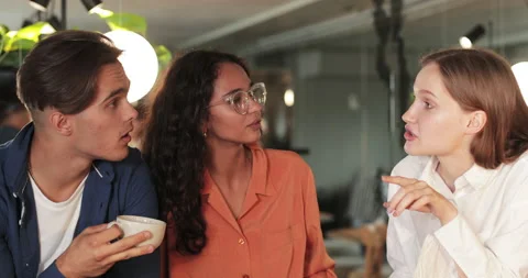 Close up view of young multiethnic startupers discussing idea while drinking Stock-Footage 135723340