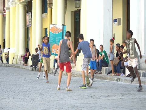 Close-up view young naughty cubano children teenagers play soccer on square in Stock Footage 69784189