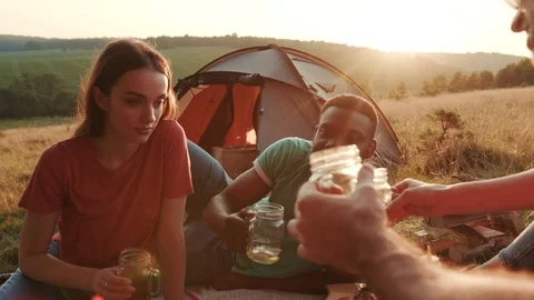 Close up view of young people having camping party outdoors, cheering up with Видео 97255368