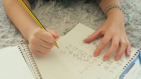 Close-up view of young student diligently solving complex math problems in .. Stock Footage 318367002