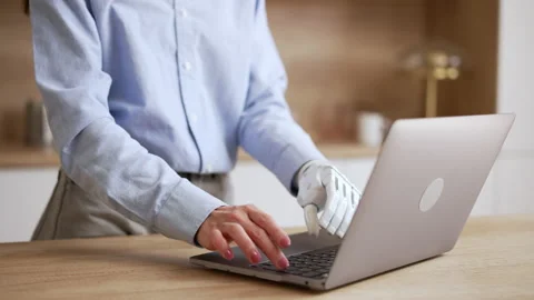 Close view of young woman with bionic hand is working with laptop and standing Stock Footage 194494866