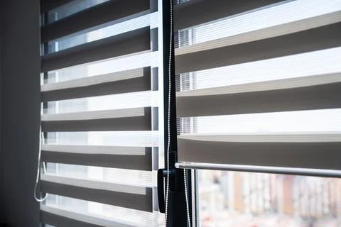 Close-up view of zebra roller blinds and chain mechanism on modern glass window 스톡 사진