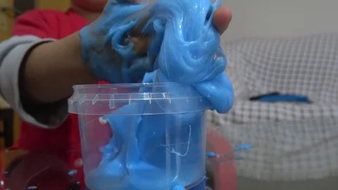 Close up viewing hands of kid playing with sticky slime Stock Footage 125554948