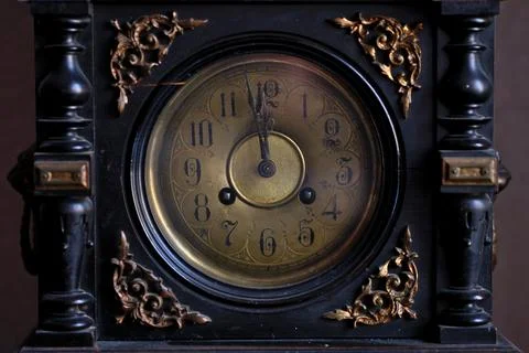 Close-up of Vintage Antique Clock Showing Almost Midnight on Black Background Stock Photos