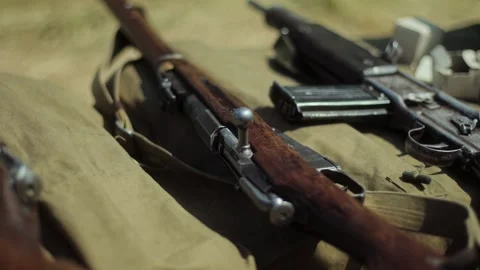 Close-up vintage bolt-action Soviet Mosin rifle near German automatic weapon and Stock Footage 306366938