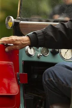 Close-up of vintage car driver operating classic dashboard and steering Stock Photos