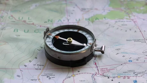 Close up of vintage compass on a mountain map with trails Stock Footage 248896753