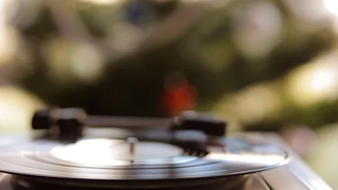 Close up: Vintage gramophone play back vinyl plate. Background: Christmas tree. Stock Footage 70741409