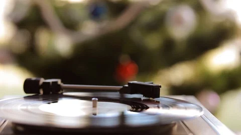 Close up: Vintage gramophone play back vinyl plate. Background: Christmas tree. Stock Footage 70769996