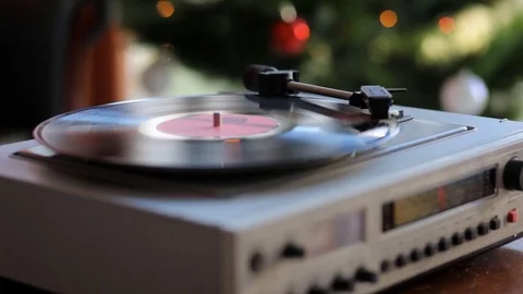 Close up: Vintage gramophone play back vinyl plate. Background: Christmas tree. Stock Footage 70796498