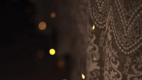 Close-up of vintage patterned lace with glowing garland lights Stock Footage 339694841