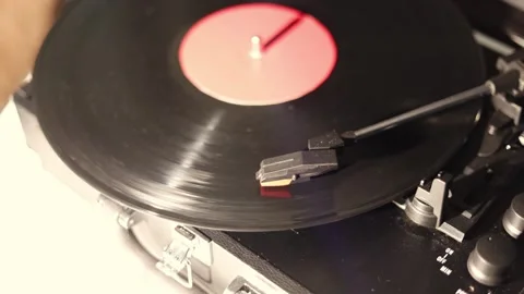 Close-up of a vintage record player spinning a vinyl disc with a red label Stock Footage 337104418