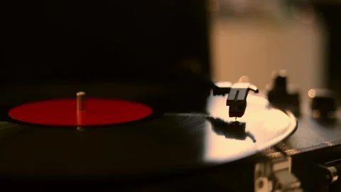Close-up of a vintage record player spinning a vinyl disc with warm lighting Stock Footage 337104456