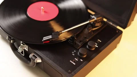Close-up of a vintage record player with a spinning vinyl disc and red label Stock Footage 339004974