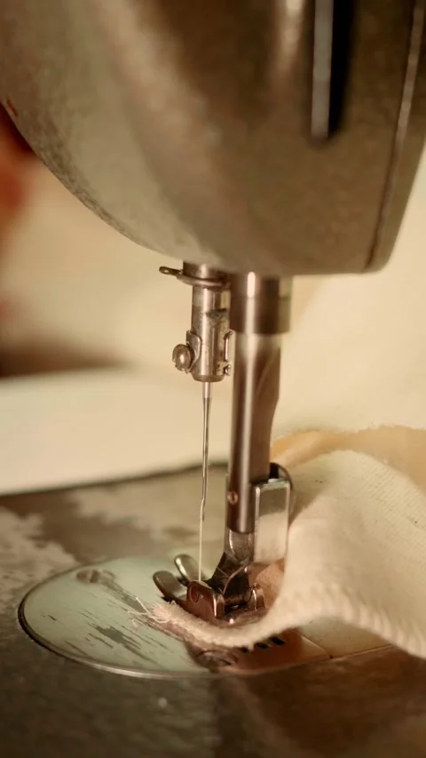 Close-Up of Vintage Sewing Machine Needle Stitching Light-Colored Fabric Stock Footage 341908649