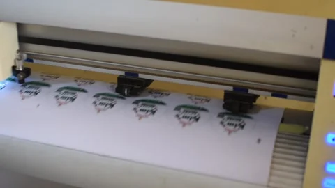 Close-up of vinyl cutter machine producing custom round stickers for branding 動画素材 326932020