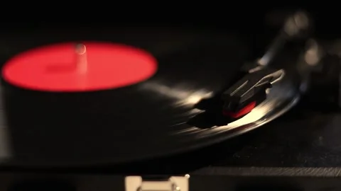 Close-up of a vinyl record spinning on a turntable with a red label Stock Footage 337104444