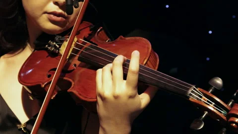 Close-up of violin playing on stage with warm lighting Video stock 301558711