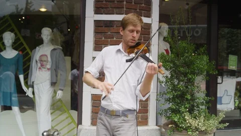 Close-up of violinist performing outside a store Stock Footage 103430168