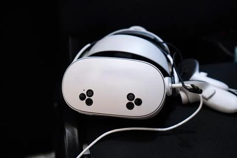 Close-up of a virtual reality headset resting on a black surface, featuring.. Fotos de archivo
