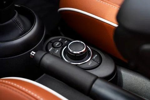 Close-up of volume controller and buttons on black dashboard between orange skin Stock Photos