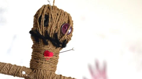 Close-up voodoo doll turns round slowly on white background Stock Footage 114361621