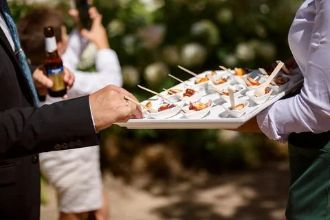 Close-up of a waiter offering bite-size appetizers on a tray Stock Photos