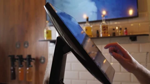 A close-up of a waiter or bartender working at a computer in a cafe. Video stock 288333041
