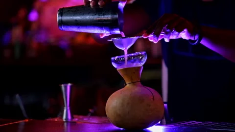 Close up of a waiter pouring liquid through a strainer into a calabash Stock Footage 240919844