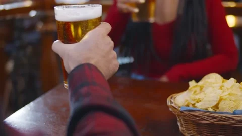 Close up of waiter in safety gloves serving glasses of beer to customers in pub Stock Footage 146909899
