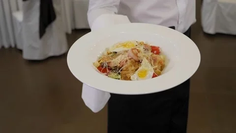 Close-up of a waiter serving a salad of fresh vegetables in a restaurant. Stock Footage 168248252