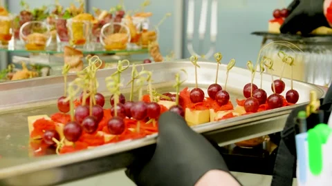 Close-up of waiter's hands laying out canape skewers on the buffet table. Stock Footage 277284017
