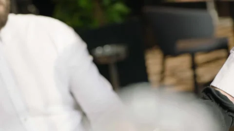 A close-up of the waiter's hands placing the drinks on the table Stock Footage 232562736