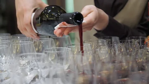 Close-up of waiter's hands pouring wine into glasses at a buffet table. Stock Footage 269933469