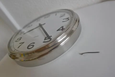 A close-up of a wall clock with a silver frame, showing the time as 10:10. Ne Stock Photos