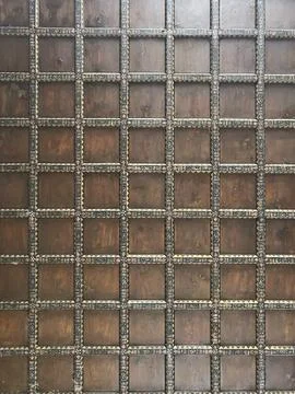 A close up of a wall with square patterns, possibly made of wood or brickwork Stock Photos