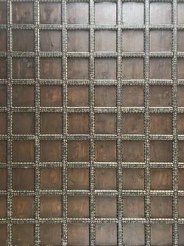 A close up of a wall with square patterns, possibly made of wood or brickwork Stock Photos