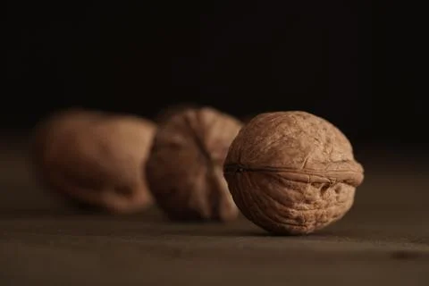 Close-up of walnut kernels and shelled nuts on a wooden table on a dark Foto stock