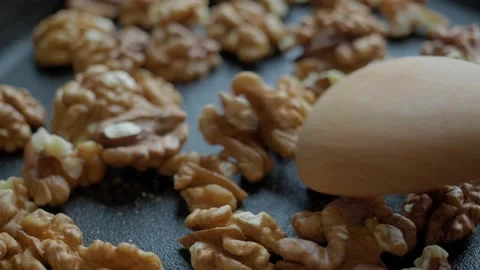 Close up of walnuts being roasted in black spinning pan. Stock Footage 222200780