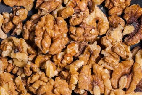 Close up of walnuts in dark grey cast iron pan for roasting spices Stock Photos