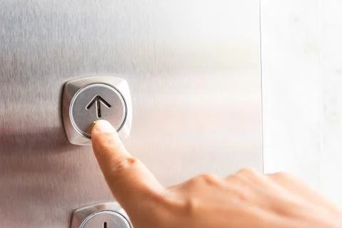 Close up waman hand press a up button of elevator inside the building for upp Foto stock