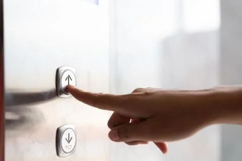 Close up waman hand press a up button of elevator inside the building for upp Foto stock